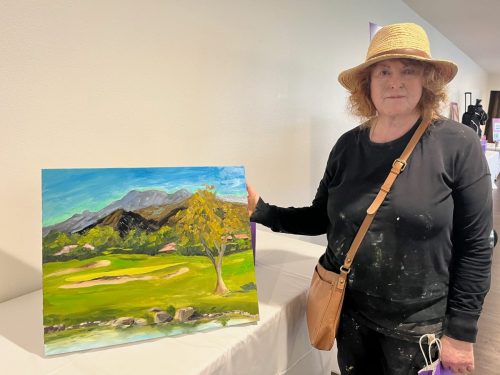Plein Art artist with the painting she created on the course and offered to the Silent Auction